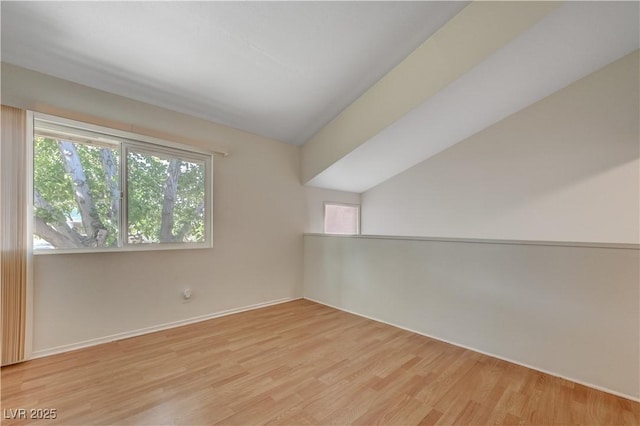 bonus room with lofted ceiling and light wood-type flooring