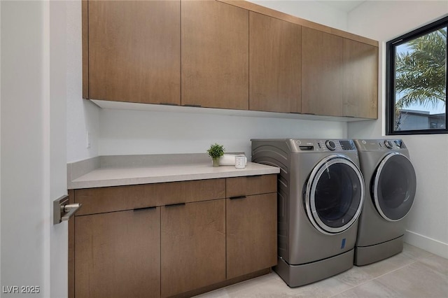 laundry area with separate washer and dryer, light tile patterned floors, and cabinets