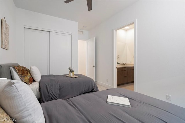 carpeted bedroom featuring ceiling fan, connected bathroom, sink, and a closet