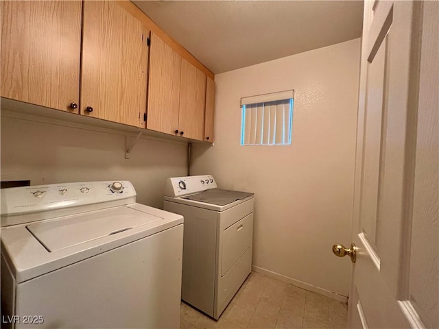 clothes washing area featuring washing machine and dryer and cabinets