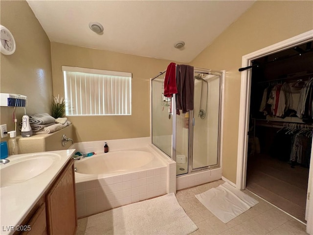 bathroom featuring vaulted ceiling, vanity, shower with separate bathtub, and tile patterned flooring