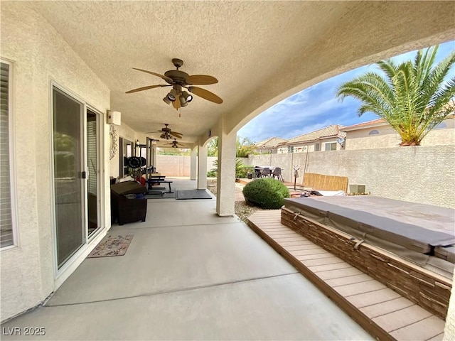 view of patio / terrace with ceiling fan and a covered hot tub