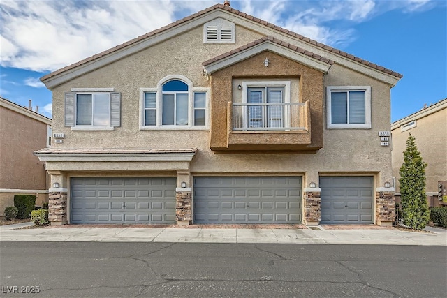 multi unit property featuring a garage and a balcony