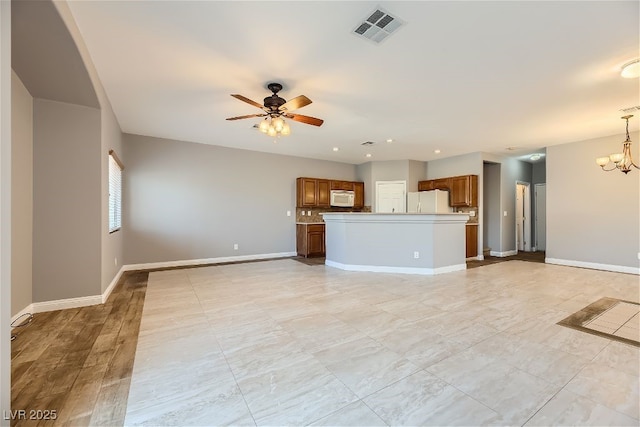 unfurnished living room featuring ceiling fan with notable chandelier