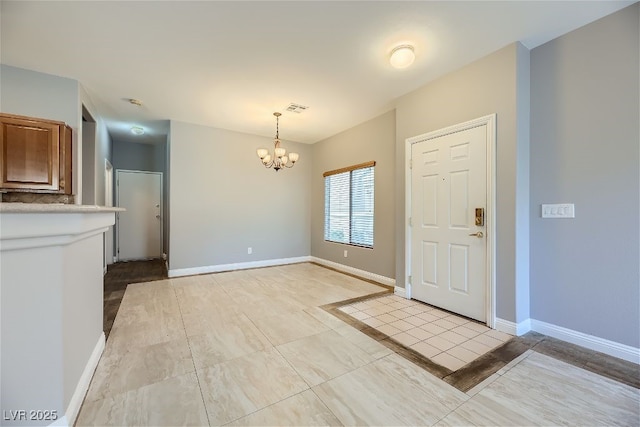 tiled foyer entrance with a notable chandelier