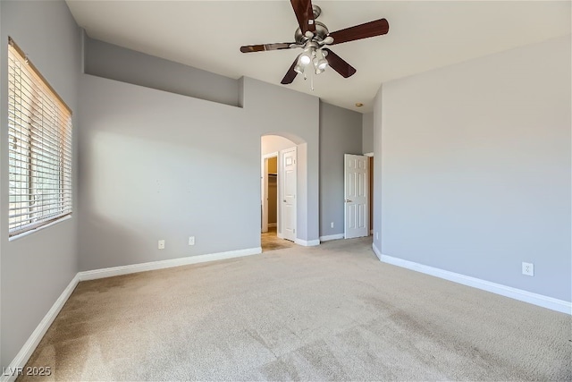 spare room with a high ceiling, light carpet, and ceiling fan