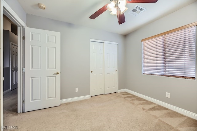 unfurnished bedroom with light colored carpet, ceiling fan, and a closet