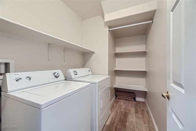 washroom featuring wood-type flooring and separate washer and dryer