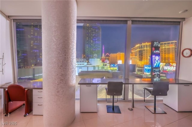 tiled dining area featuring a wall of windows