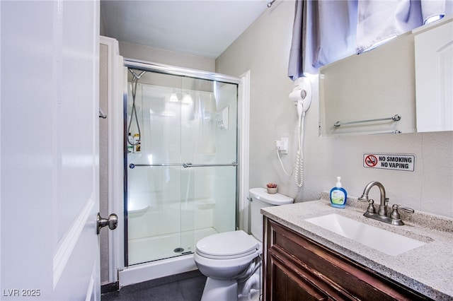 bathroom with vanity, toilet, and a shower with shower door