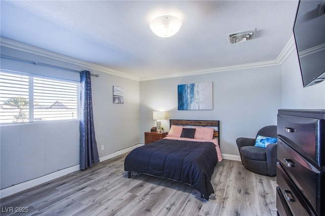 bedroom with ornamental molding, a textured ceiling, and light wood-type flooring