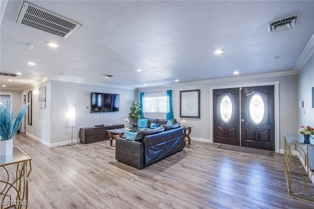 living room with crown molding, a textured ceiling, and light wood-type flooring