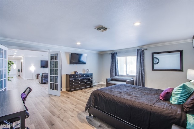 bedroom featuring ornamental molding, a textured ceiling, light wood-type flooring, and french doors