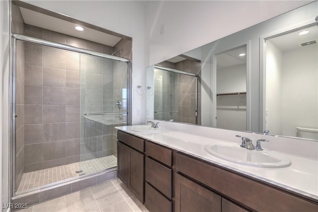 bathroom featuring a shower with door, vanity, and tile patterned floors