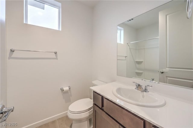 bathroom with tile patterned flooring, vanity, toilet, and walk in shower