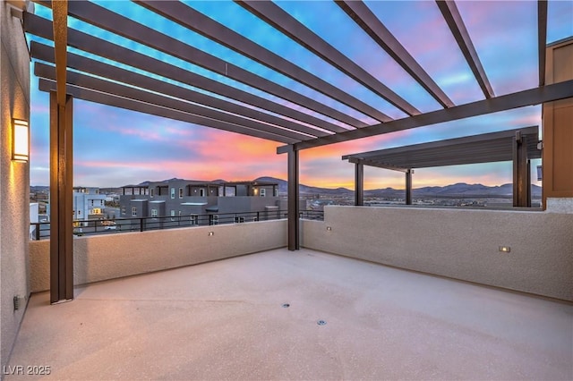 patio terrace at dusk with a mountain view and a pergola