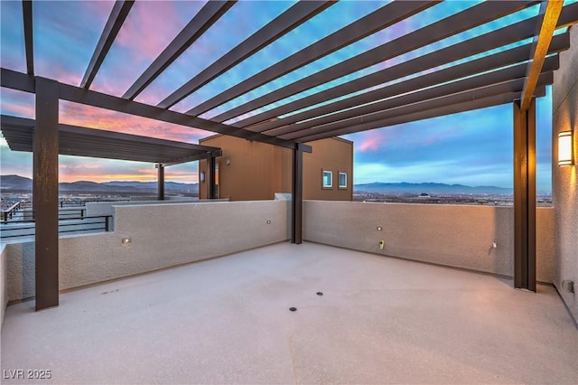 patio terrace at dusk with a mountain view and a pergola