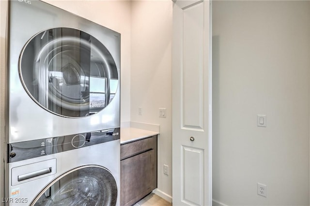 laundry room with cabinets and stacked washing maching and dryer