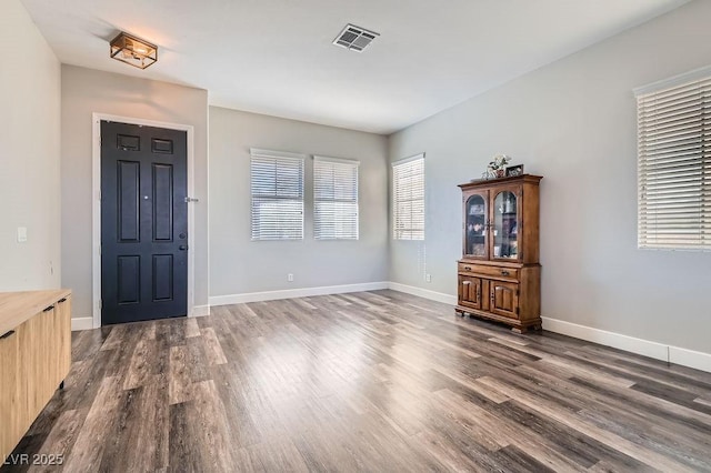 foyer entrance featuring dark wood-type flooring, visible vents, and baseboards