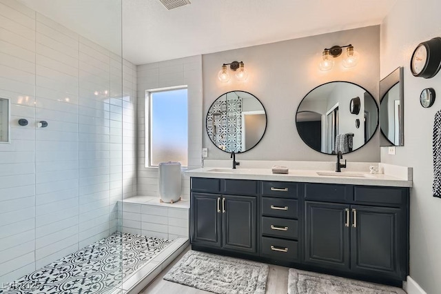 bathroom with walk in shower, a sink, and double vanity