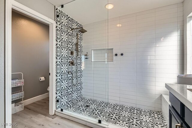 bathroom with hardwood / wood-style flooring, a tile shower, and toilet