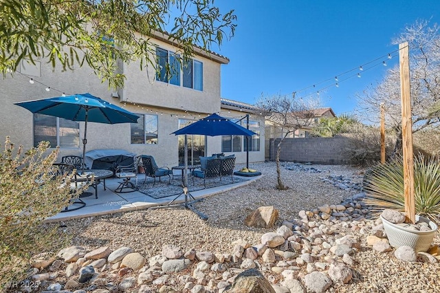 back of house featuring a tile roof, fence, a patio, and stucco siding