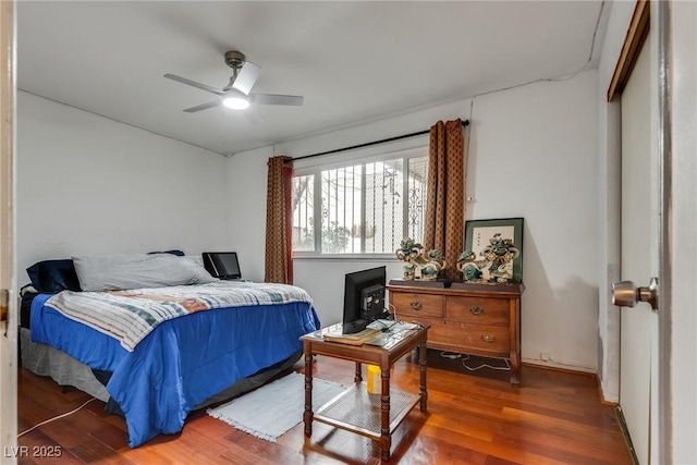 bedroom with dark wood-type flooring, ceiling fan, and a closet