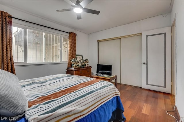 bedroom with hardwood / wood-style flooring, ceiling fan, and a closet