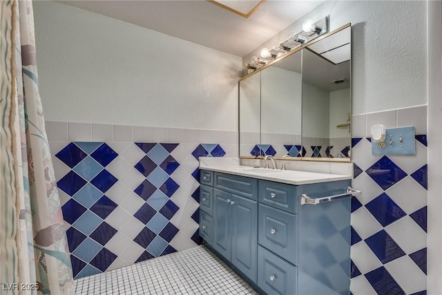 bathroom featuring tile walls, vanity, and tile patterned flooring