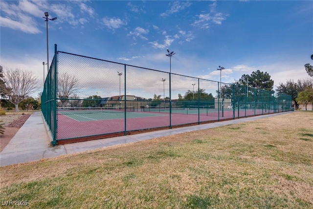 view of tennis court featuring a lawn