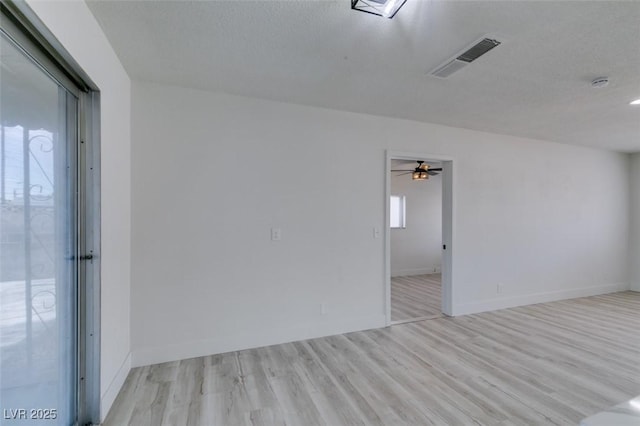 empty room featuring ceiling fan, a textured ceiling, and light wood-type flooring