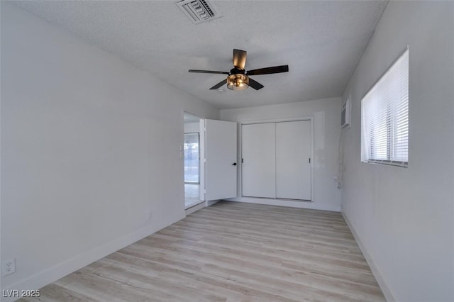 spare room featuring ceiling fan, a textured ceiling, and light wood-type flooring