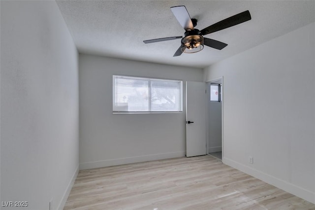 spare room with ceiling fan, light hardwood / wood-style flooring, and a textured ceiling