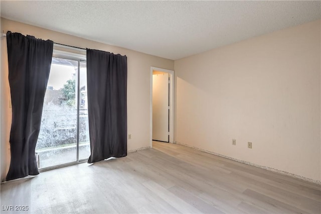 empty room featuring a textured ceiling and light wood-type flooring