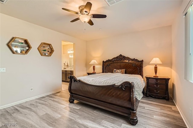 bedroom featuring ceiling fan, light wood-type flooring, and ensuite bath