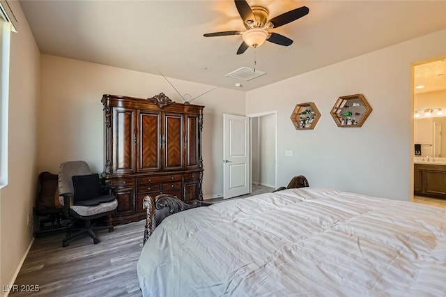 bedroom with ceiling fan, ensuite bath, sink, and light wood-type flooring