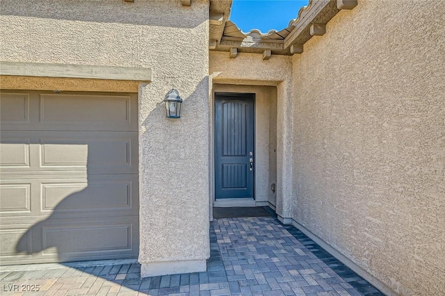 view of exterior entry with a garage