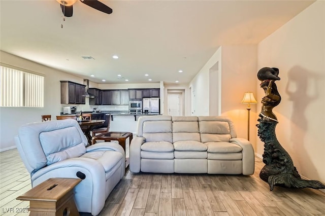 living room featuring ceiling fan and light wood-type flooring