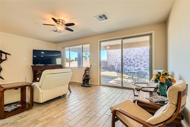 living room with ceiling fan and light hardwood / wood-style flooring