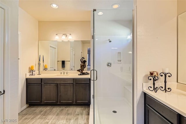 bathroom with a shower with door, wood-type flooring, and vanity