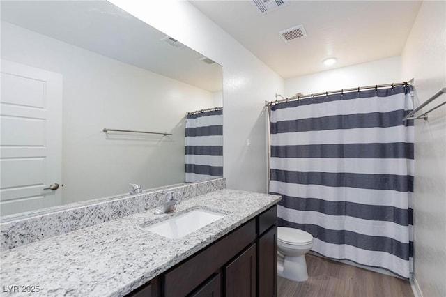 bathroom featuring a shower with curtain, wood-type flooring, toilet, and vanity