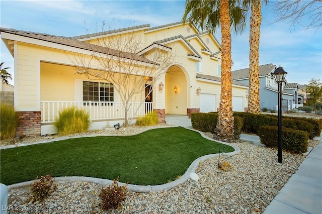 view of front of home featuring a garage, a front yard, and a porch