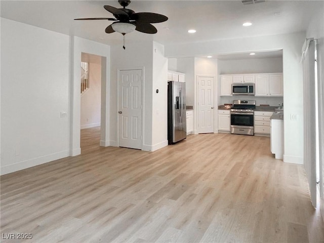 kitchen featuring ceiling fan, stainless steel appliances, white cabinets, and light wood-type flooring