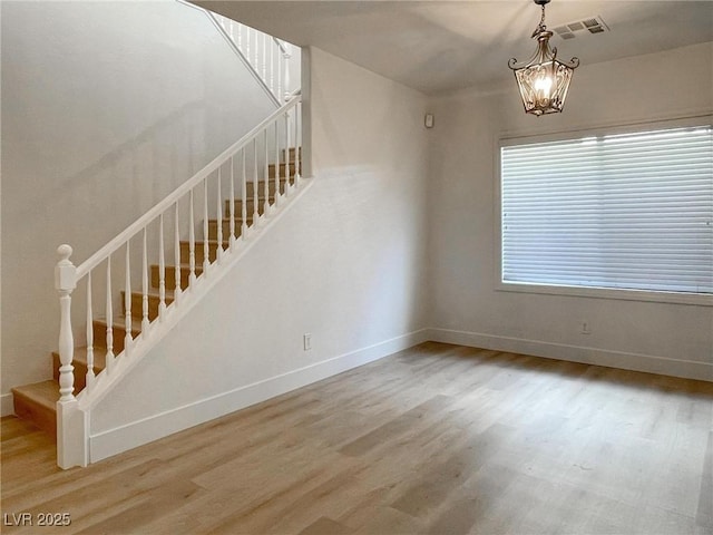 interior space with wood-type flooring and an inviting chandelier