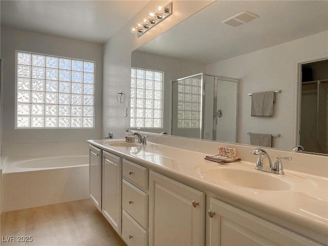 bathroom featuring vanity, wood-type flooring, shower with separate bathtub, and a healthy amount of sunlight