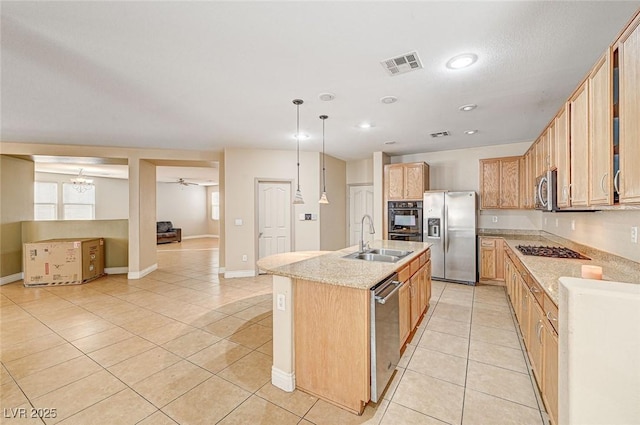 kitchen featuring sink, decorative light fixtures, light tile patterned floors, an island with sink, and stainless steel appliances