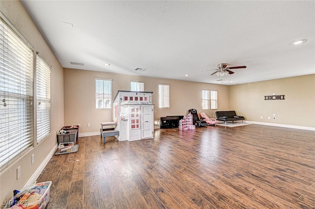 interior space with ceiling fan, plenty of natural light, dark hardwood / wood-style floors, and a textured ceiling