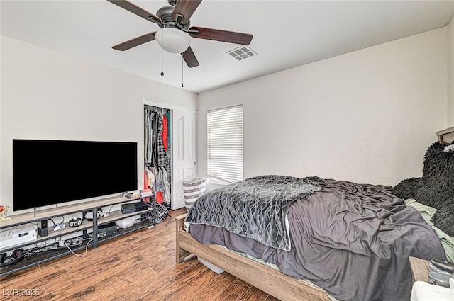 bedroom featuring hardwood / wood-style flooring, ceiling fan, and a closet