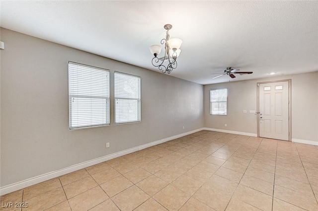 empty room featuring light tile patterned flooring and ceiling fan with notable chandelier