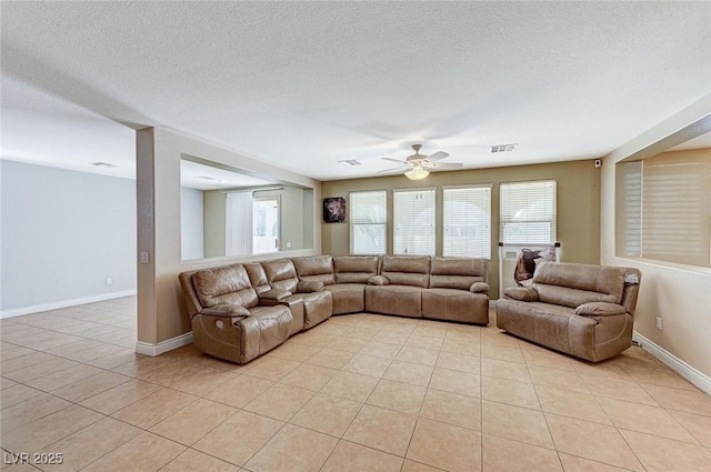 living room featuring light tile patterned floors, a textured ceiling, and ceiling fan